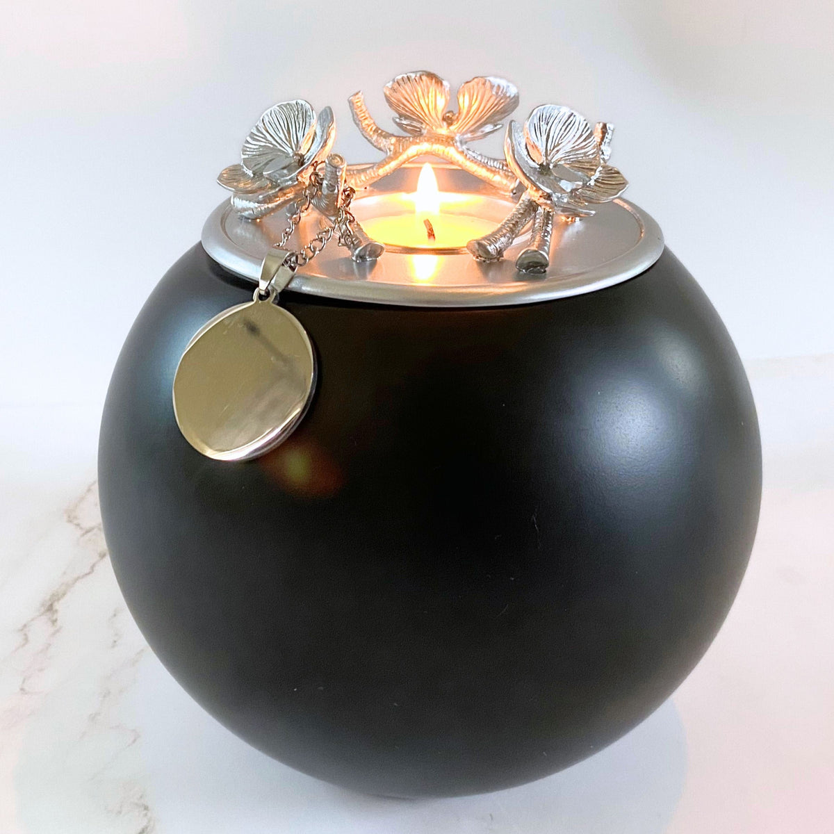 pet cremation urns for dogs onyx urn with a silver lid featuring intricate orchid flower details and a lit tealight candle in the center