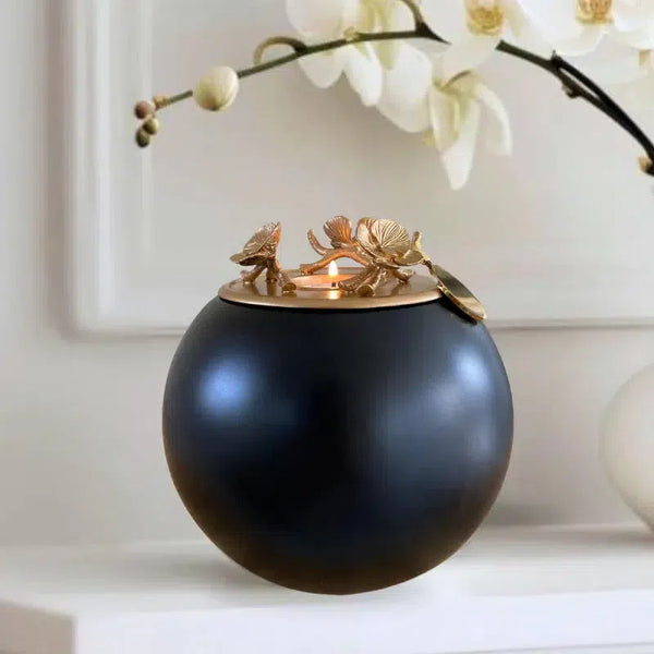 an onyx urn with gold lid placed against a wall above a shelf as a home decor